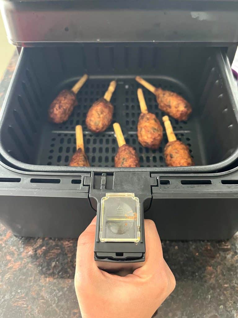 Air fryer basket filled with crispy cooked Chao Tom, showing how they look when done using the air fryer method.