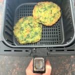 Two cooked Trader Joe’s scallion pancakes in an air fryer basket, showing how they look when finished using the air fryer method.