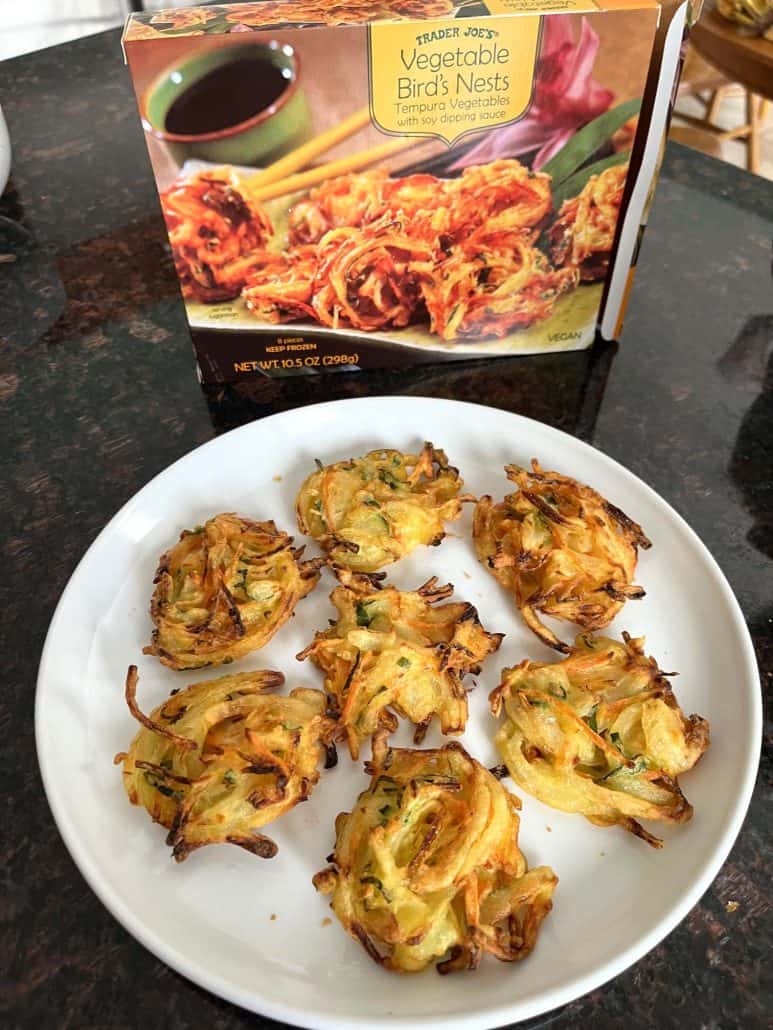 A plate of crispy, golden-brown Trader Joe’s Vegetable Bird’s Nests, freshly air-fried and ready to serve, with the original packaging in the background.