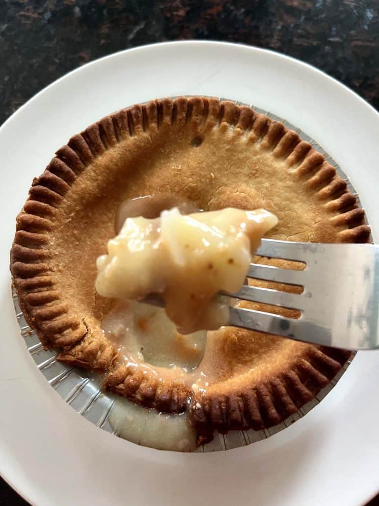 Fork lifting a bite of creamy filling from an air-fried turkey pot pie, showing the hot and delicious inside.