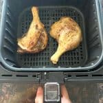 Cooked duck legs in an air fryer basket—crispy and golden brown, just like in the Air Fryer Duck Legs recipe.