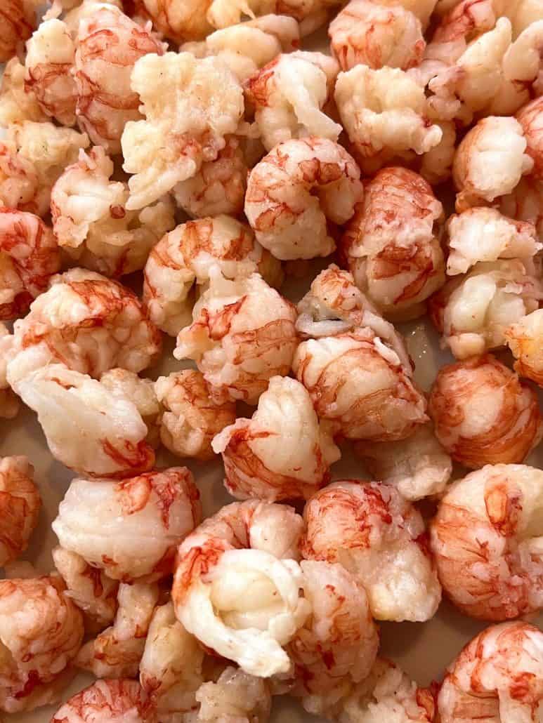 Ready to enjoy perfectly cooked langostino tails piled on a plate, for a delicious seafood meal.