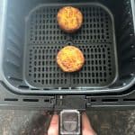 Two Jimmy Dean frittatas cooking in an air fryer basket, showing how to easily heat them from frozen for a quick breakfast.