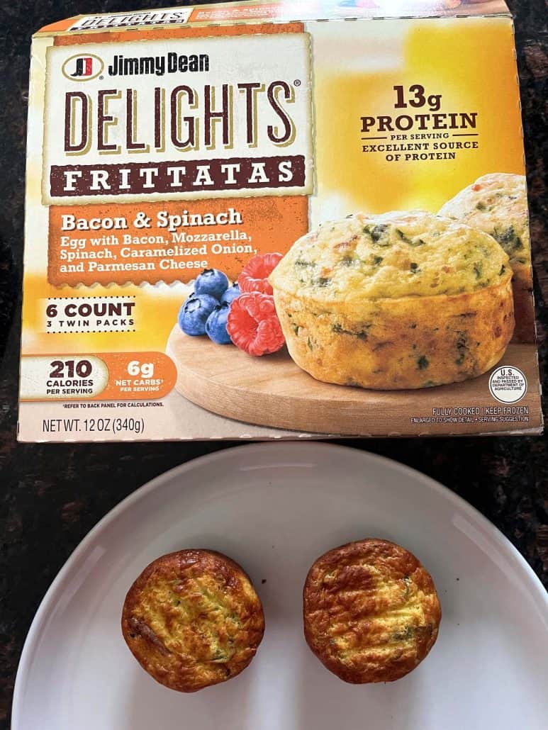 Cooked Jimmy Dean Delights Bacon & Spinach Frittatas on a plate in front of the product box, showing the finished air fryer result next to the packaging.