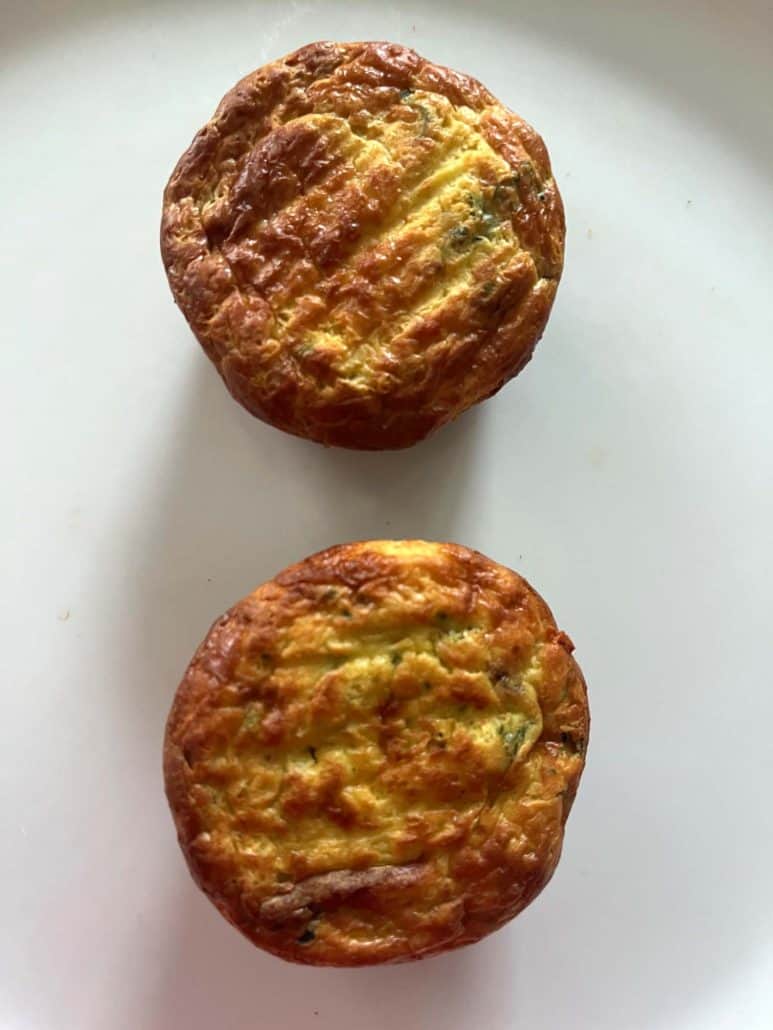 Close-up of two fully cooked Jimmy Dean frittatas on a plate, showing their golden brown tops.