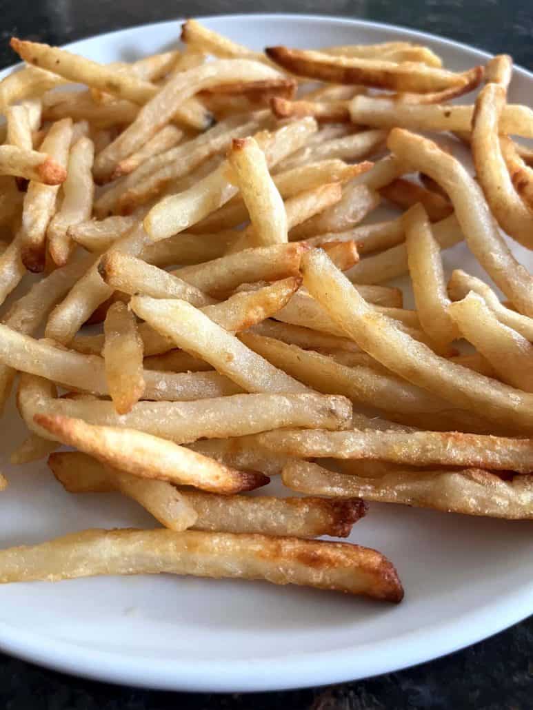 Close-up of crispy McCain Beer Battered Fries served on a white plate, ready to enjoy.