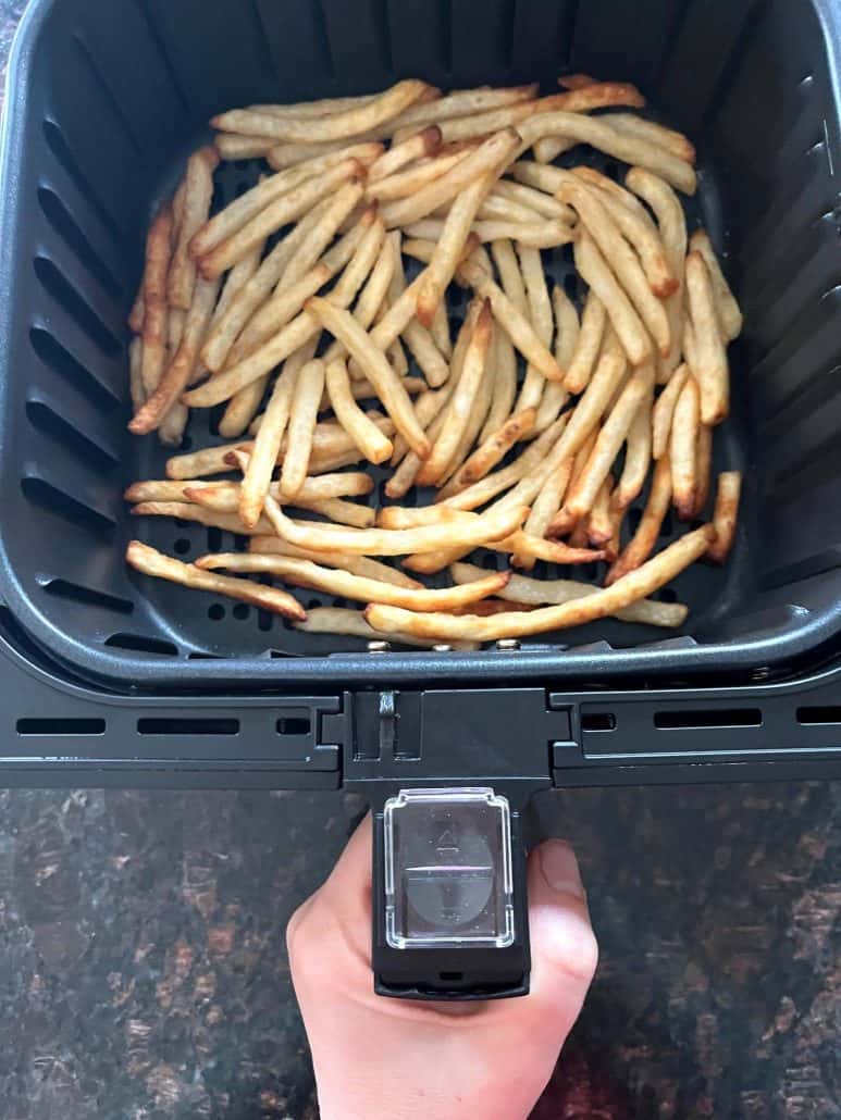 Crispy beer battered fries cooked in an air fryer basket, ready to serve.