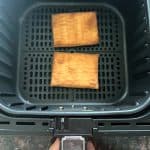 Two Pillsbury toaster pastries cooked in an air fryer basket, showing how they look perfectly browned and ready to frost.