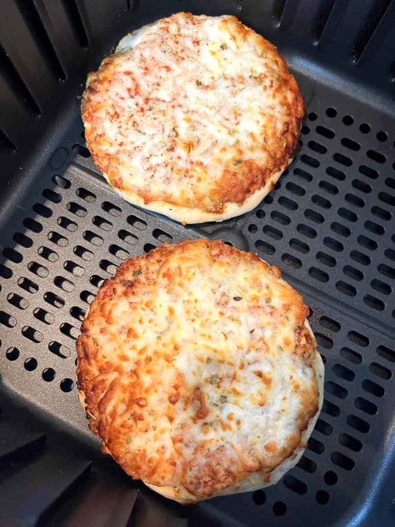 Close-up of two Trader Joe’s Bambino Pizzas cooked in the air fryer, showing their crispy golden crust and melted cheese.