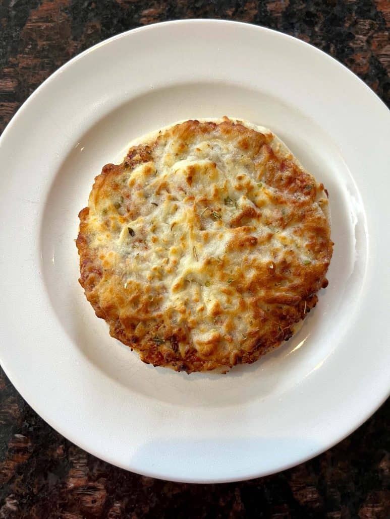 Crispy cooked Trader Joe’s Bambino Pizza served on a white plate, showing the perfect air fryer result with golden cheese and crust.
