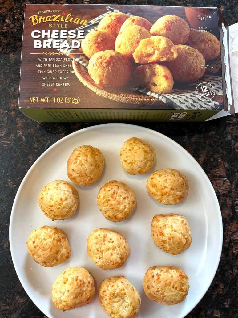 Plate of cooked Trader Joe’s Brazilian cheese bread served next to the product box, showing the finished result of this easy air fryer snack.