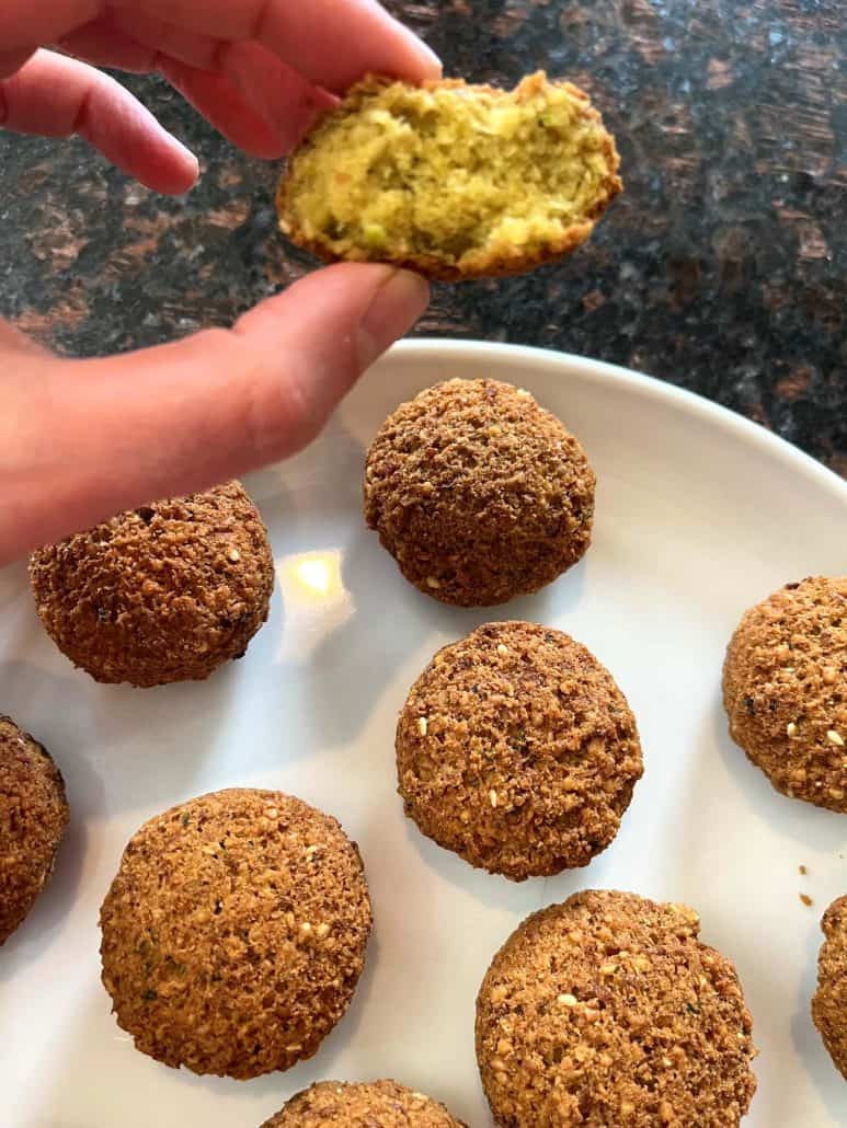 Melanie Mendelson from melaniecooks.com holding a halved Trader Joe’s Falafel showing the perfectly cooked, fluffy inside—crispy on the outside and tender on the inside.