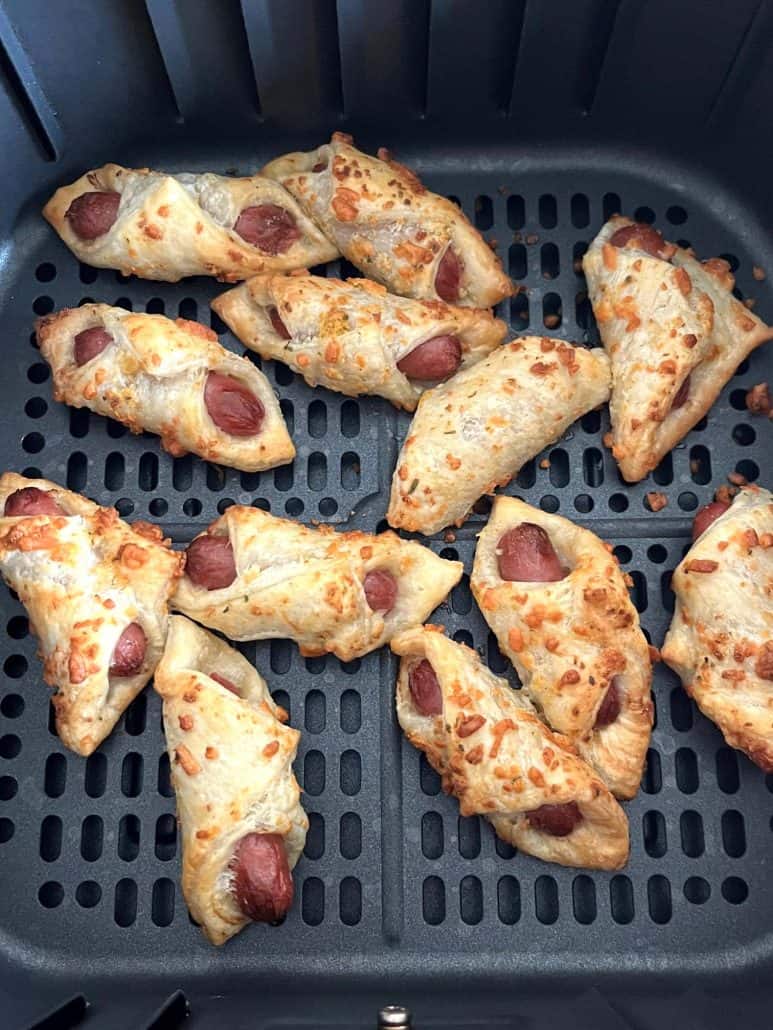 Trader Joe's Pastry Pups in the air fryer basket, showing their perfectly crispy, golden brown puff pastry right after cooking.