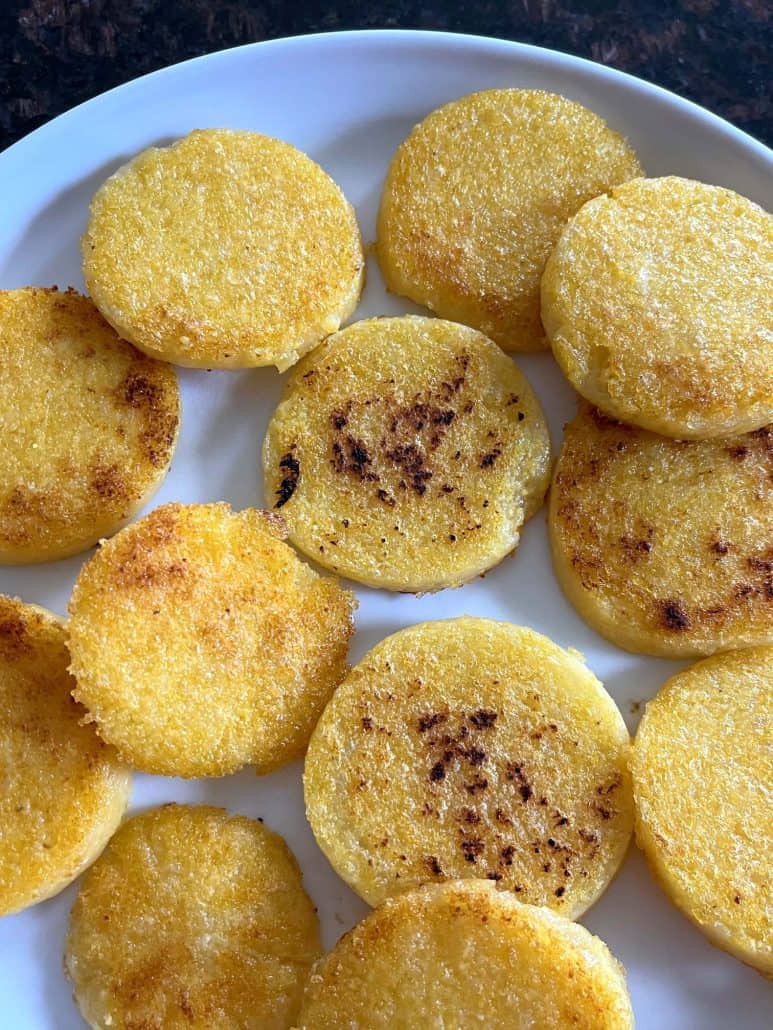A plate of crispy fried polenta slices, showcasing their golden brown texture and perfectly cooked edges.