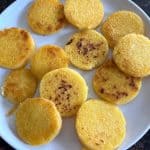 Golden, crispy fried polenta slices arranged on a white plate, showcasing the perfect texture of the crispy edges and soft interior.