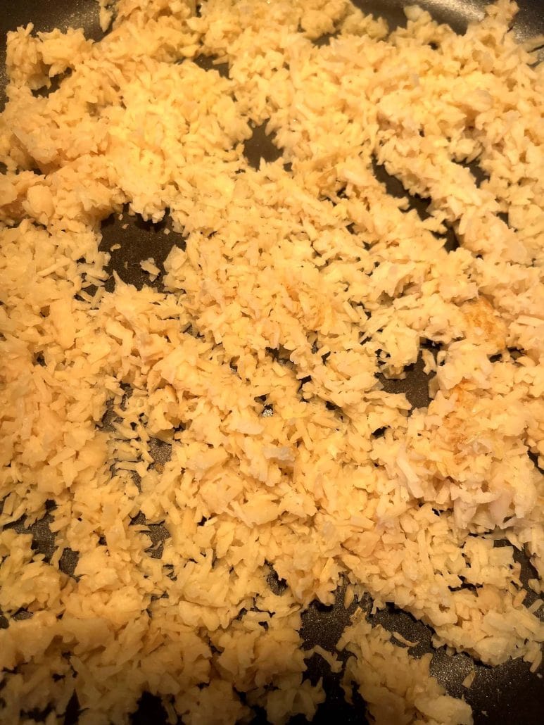 Close-up of sautéed hearts of palm rice in a skillet – fluffy, golden, and ready to serve.