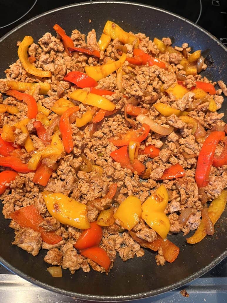 Sizzling ground turkey, bell peppers, and onions in a skillet, just before serving the Ground Turkey Fajitas recipe.