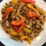 Plate of cooked ground turkey fajitas with sautéed bell peppers and onions, served as shown in the recipe.