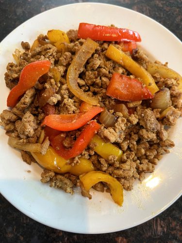 Plate of cooked ground turkey fajitas with sautéed bell peppers and onions, served as shown in the recipe.