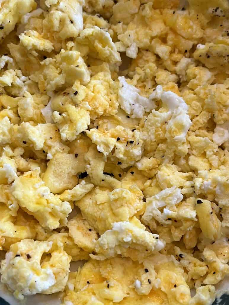 Extreme close-up of fluffy scrambled eggs made in the microwave, showing soft texture and seasoning.