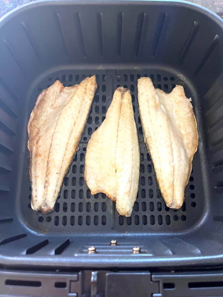 Three golden branzino fillets cooked in the air fryer basket, ready to serve from the Air Fryer Branzino Fillets recipe.