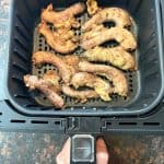 Cooked chicken necks in an air fryer basket after 20 minutes at 400°F, showing their crispy golden-brown finish from the easy Air Fryer Chicken Necks recipe.