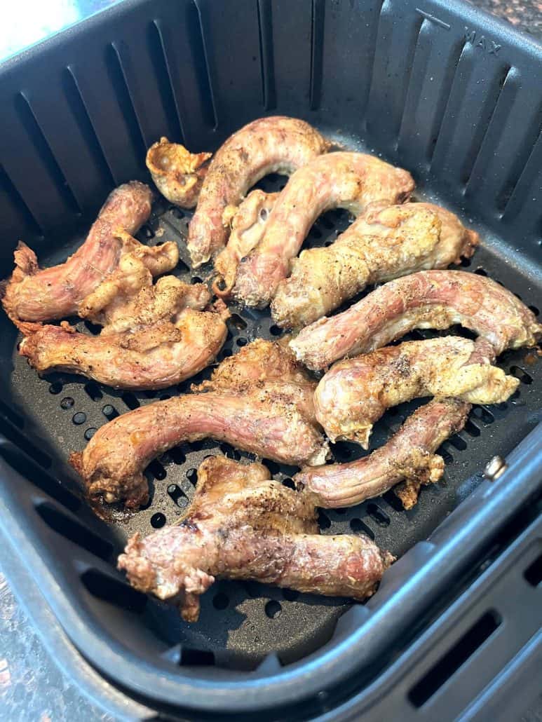 Freshly air-fried chicken necks in the air fryer basket, cooked to golden perfection as shown in the easy Air Fryer Chicken Necks recipe.