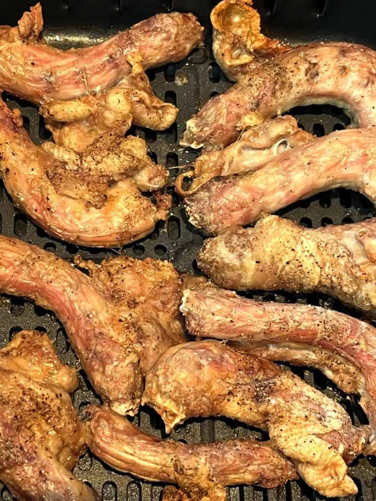 Zoomed-in image of crispy air-fried chicken necks inside the air fryer basket, highlighting their golden, well-browned finish from the Air Fryer Chicken Necks recipe.