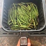 Fresh French green beans (Haricot Verts) placed in an air fryer basket, ready to be cooked for the Air Fryer French Green Beans recipe.