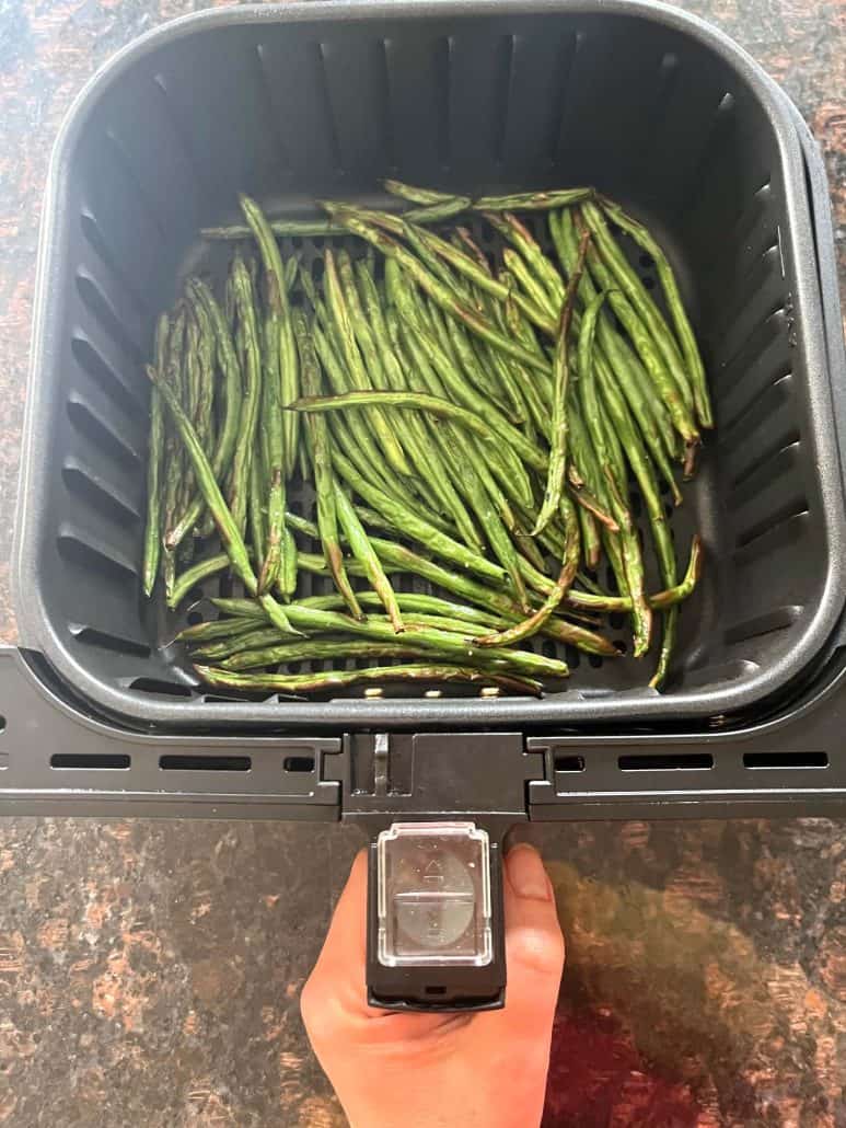 Fresh French green beans (Haricot Verts) placed in an air fryer basket, ready to be cooked for the Air Fryer French Green Beans recipe.