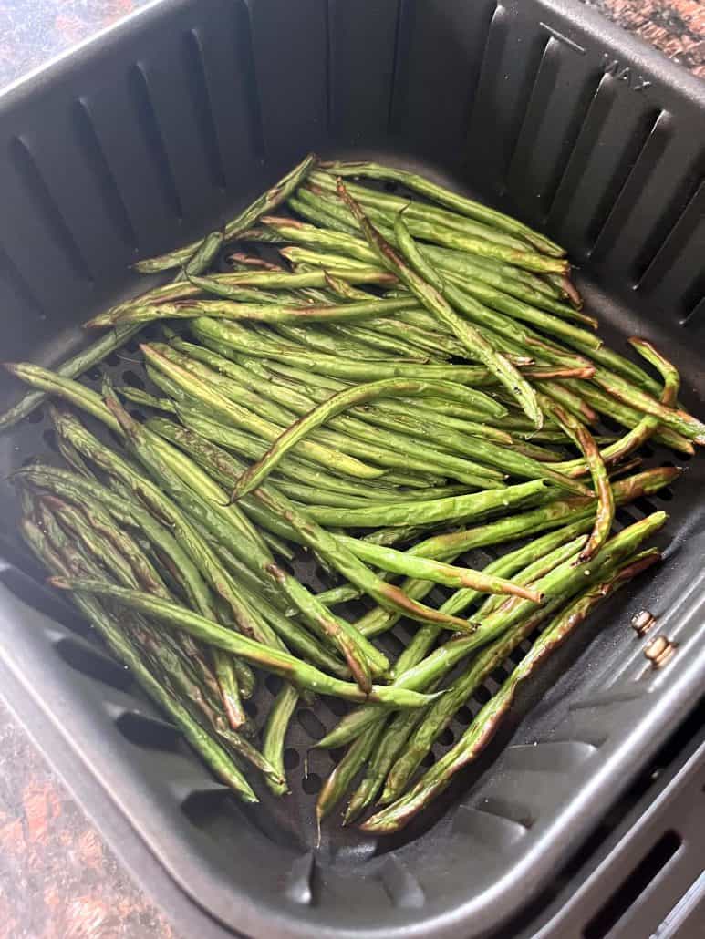 Close-up of crispy, golden-brown French green beans (Haricot Verts) freshly cooked in the air fryer, highlighting the perfect texture.