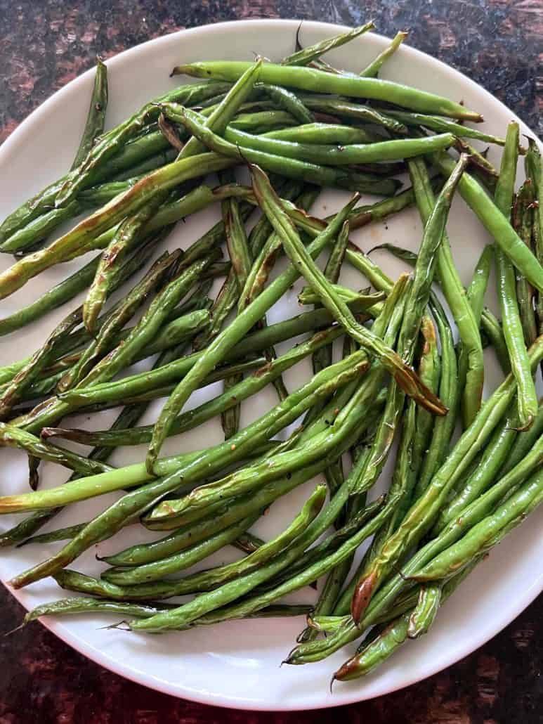 Plate of air-fried French green beans (Haricot Verts), served and ready to enjoy as a crispy and healthy side dish.