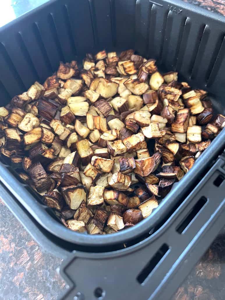 Roasted graffiti eggplant cubes in the air fryer basket, cooked to golden perfection.