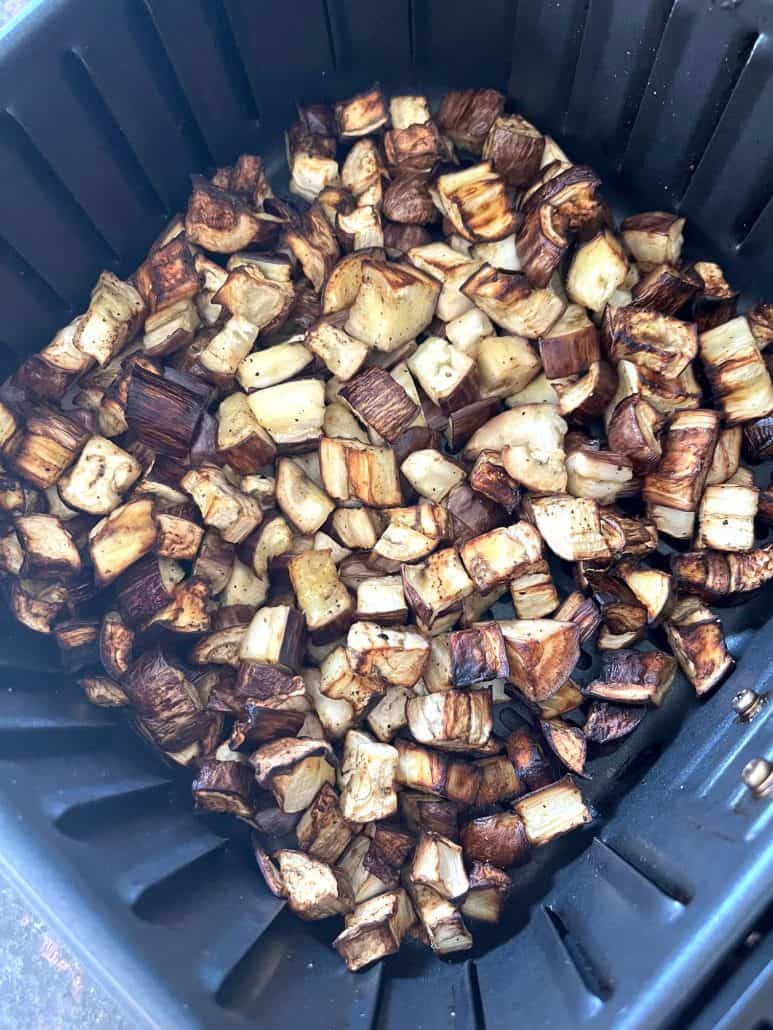Crispy air-fried graffiti eggplant cubes shown inside the air fryer basket.