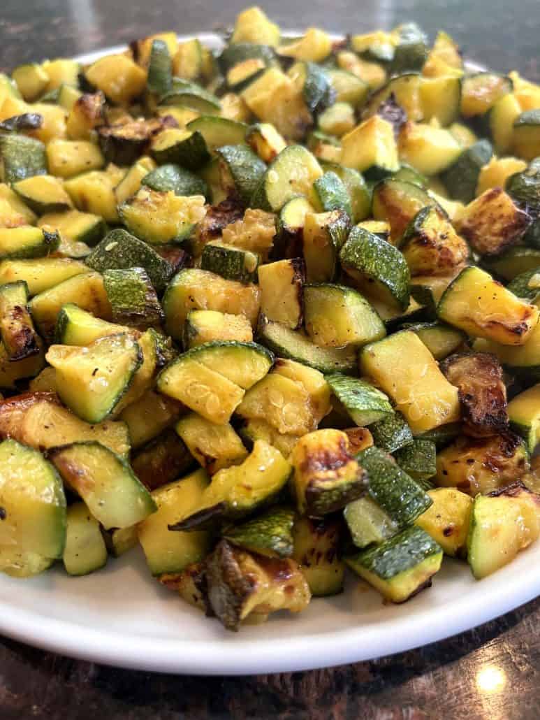 Side view of golden air fried Lita squash on a plate, showing crispy edges and tender texture.