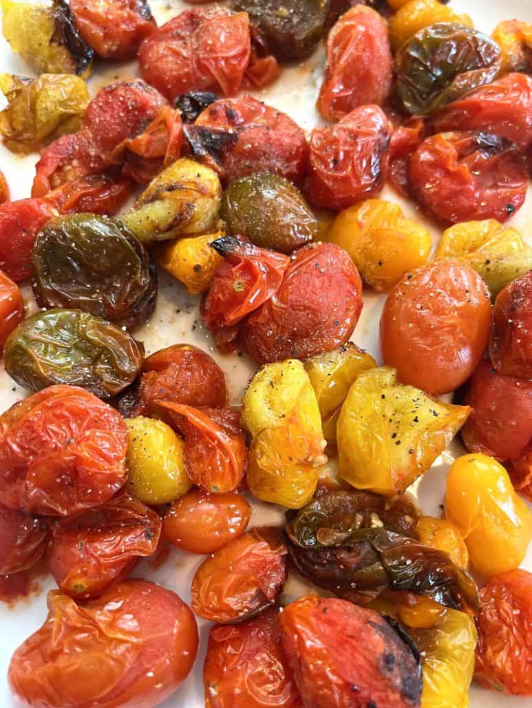 Colorful close-up of roasted medley tomatoes on a plate, highlighting the caramelized edges and vibrant hues.