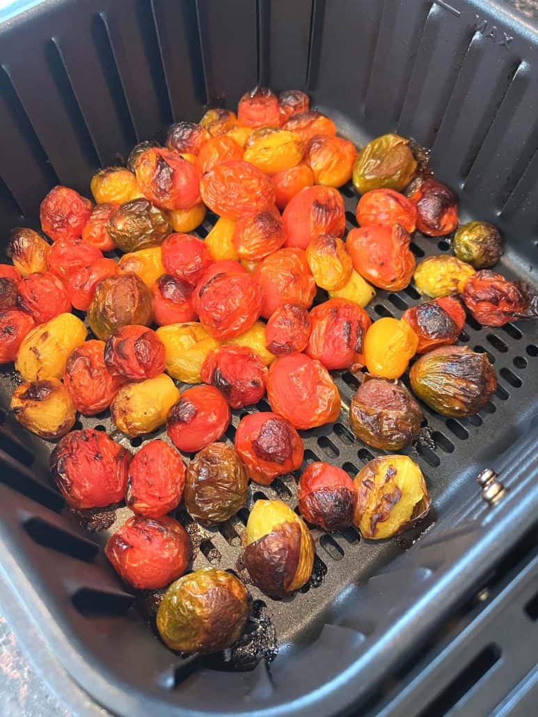 Golden brown medley tomatoes freshly roasted in the air fryer, ready to be seasoned and served as part of the Air Fryer Medley Tomatoes recipe.