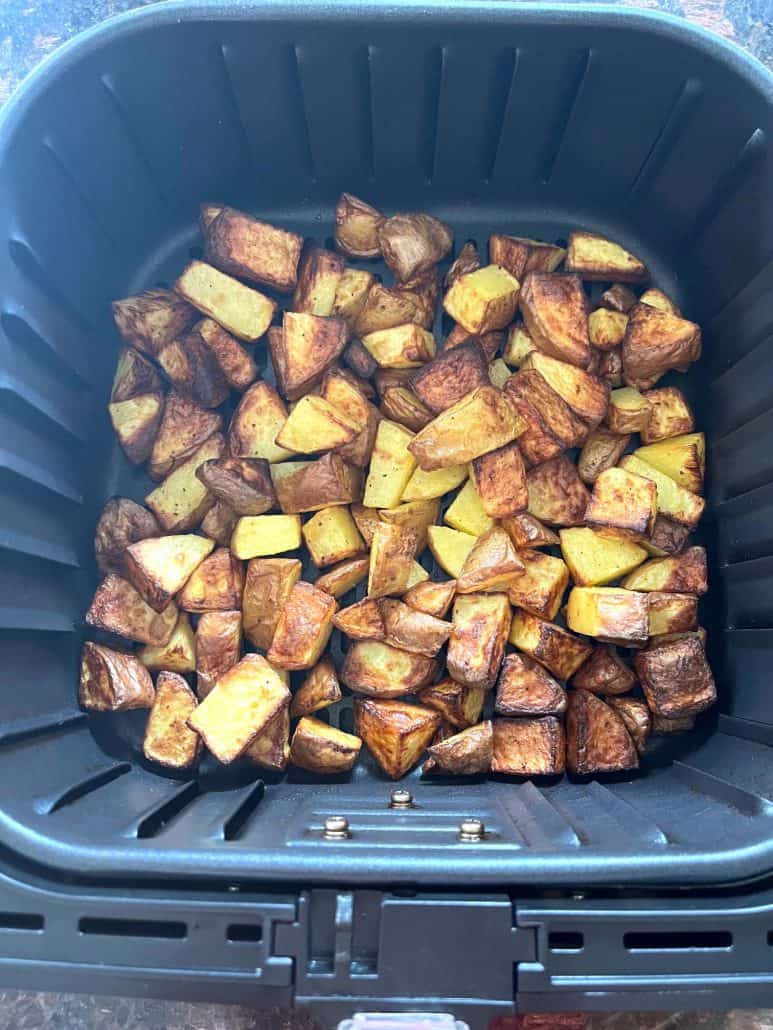 Crispy, golden skin-on potato cubes cooked in the air fryer—just finished and perfectly browned.