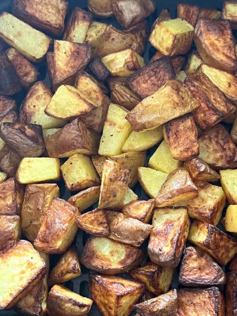 Close-up of crispy, golden-brown skin-on potato cubes right after air frying—showcasing the perfect texture.