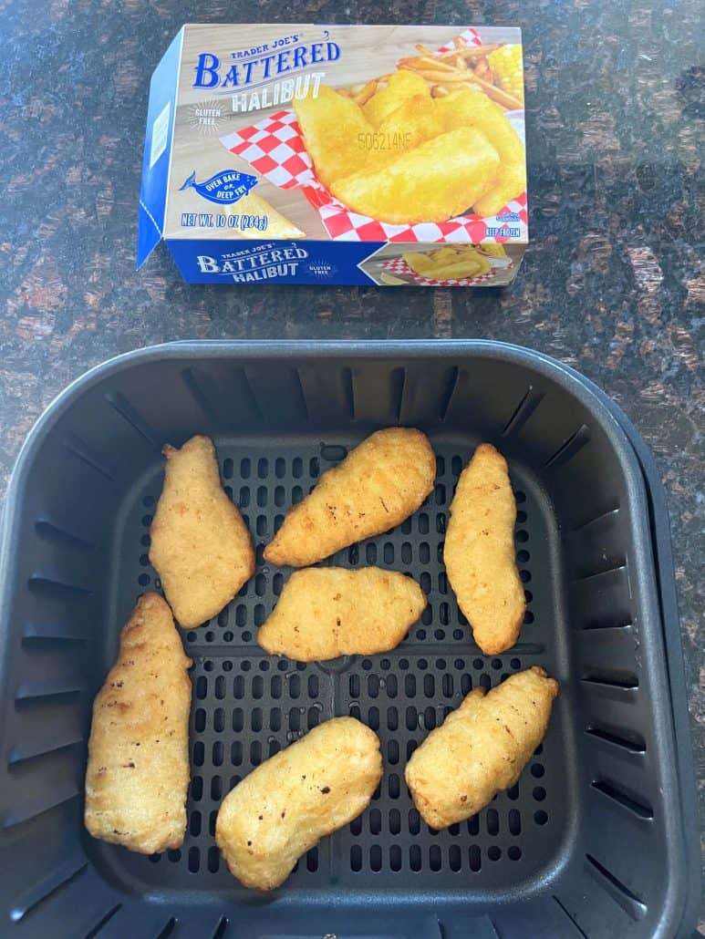 Air fryer basket filled with cooked Trader Joe’s battered halibut fillets, with the product box shown in the background.
