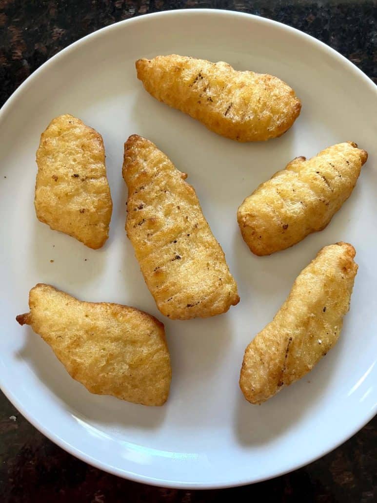 Cooked Trader Joe’s battered halibut fillets served on a white plate, hot and crispy from the air fryer.