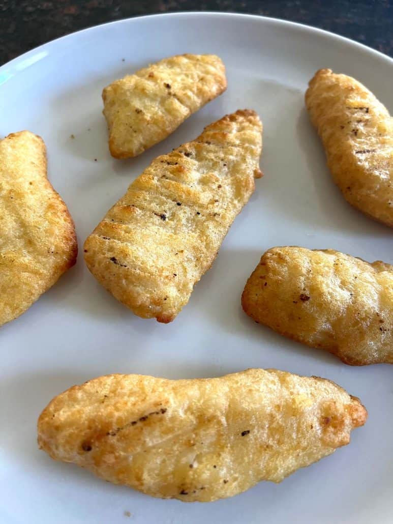 Crispy air-fried Trader Joe’s battered halibut fillets on a white serving plate, ready to eat.