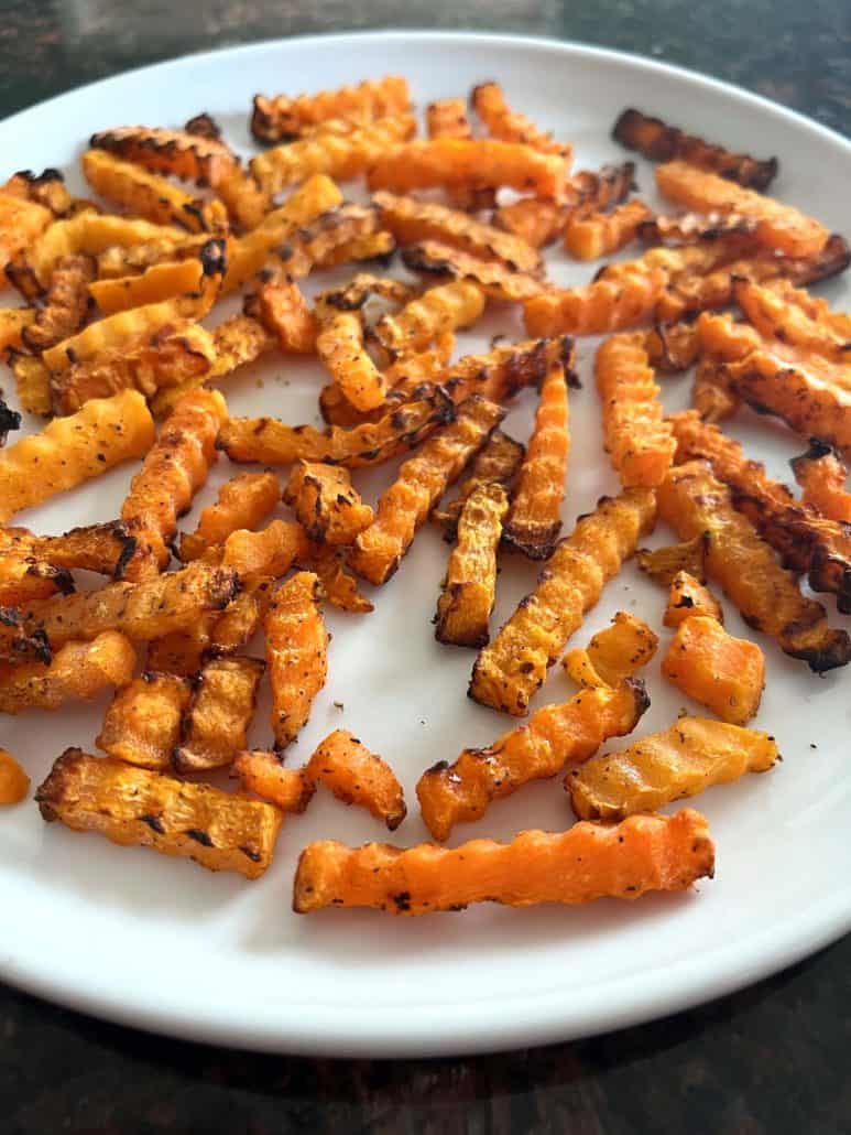 Side view of crispy air-fried Trader Joe’s Butternut Squash Zig-Zags on a white plate, showing their golden edges and ready-to-eat texture.