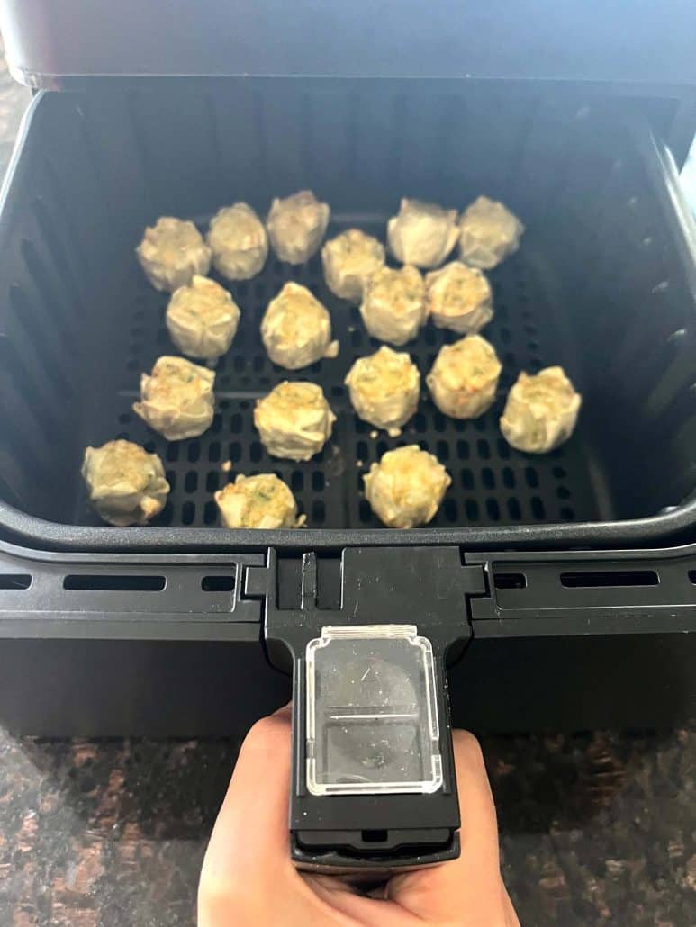 Cooked Trader Joe’s Chicken Shu Mai dumplings inside the air fryer basket, showing their golden tops.