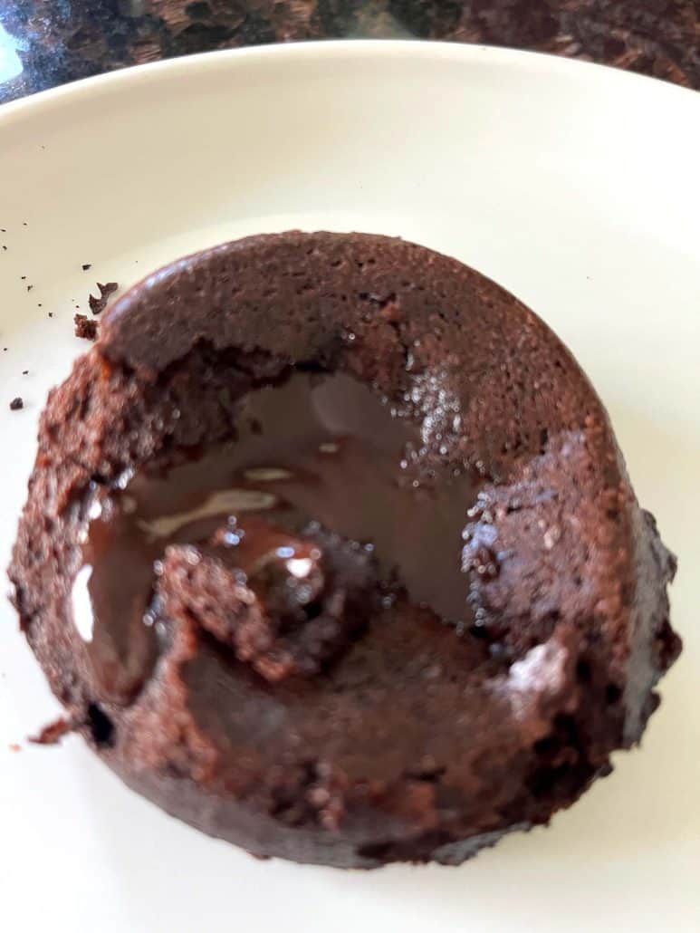 Warm chocolate lava cake on a plate with melted center exposed, showcasing the gooey inside after air frying Trader Joe’s frozen dessert.