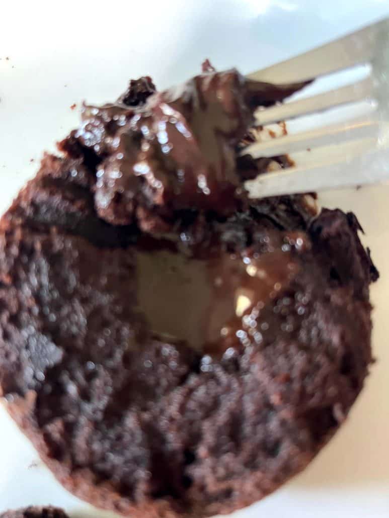 Close-up of a fork lifting a gooey bite from a Trader Joe’s chocolate lava cake, revealing the melted chocolate center and fudgy texture.