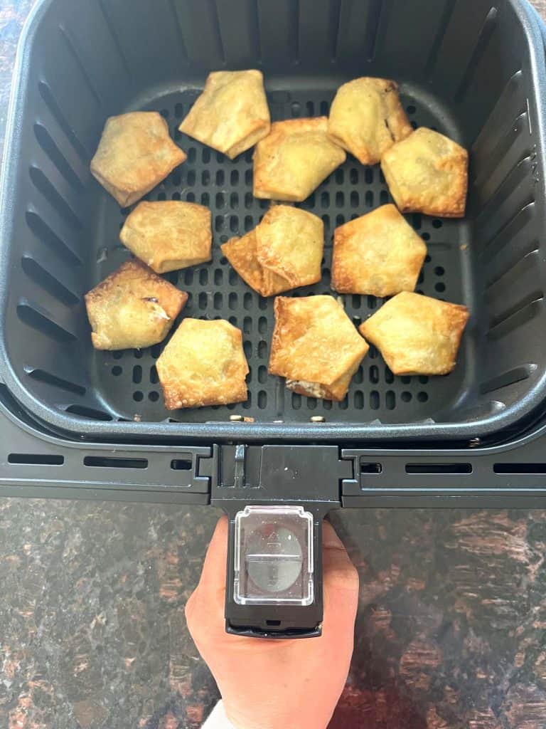 Crispy Trader Joe’s jalapeño cream cheese wontons freshly cooked in the air fryer basket, ready to serve as a quick and easy appetizer.