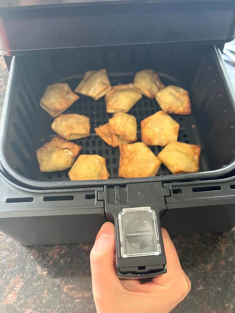 Golden brown jalapeño cream cheese wontons fresh out of the air fryer, shown as part of the step-by-step recipe tutorial.
