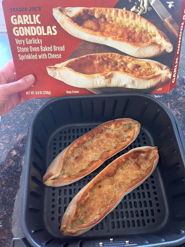 Holding the Trader Joe’s Garlic Gondolas box above the air fryer basket filled with freshly cooked gondolas, showing the before-and-after from the Air Fryer Garlic Gondolas recipe