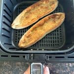 Two Trader Joe’s Garlic Gondolas perfectly cooked and golden brown in an air fryer basket, ready to serve.